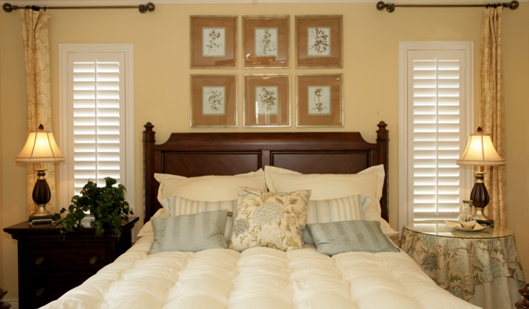 Beige bedroom with white plantation shutters covering windows in Seattle 